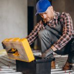 Service man instelling house heating system under the floor